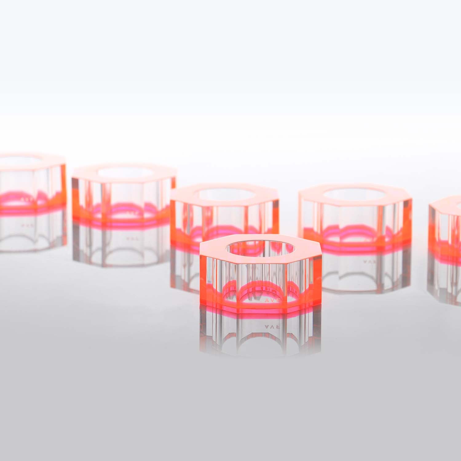 Abstract and minimalist arrangement of transparent cylinders with pink accents.