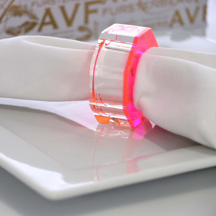 Neon pink-orange transparent bangle shines on mannequin's wrist.