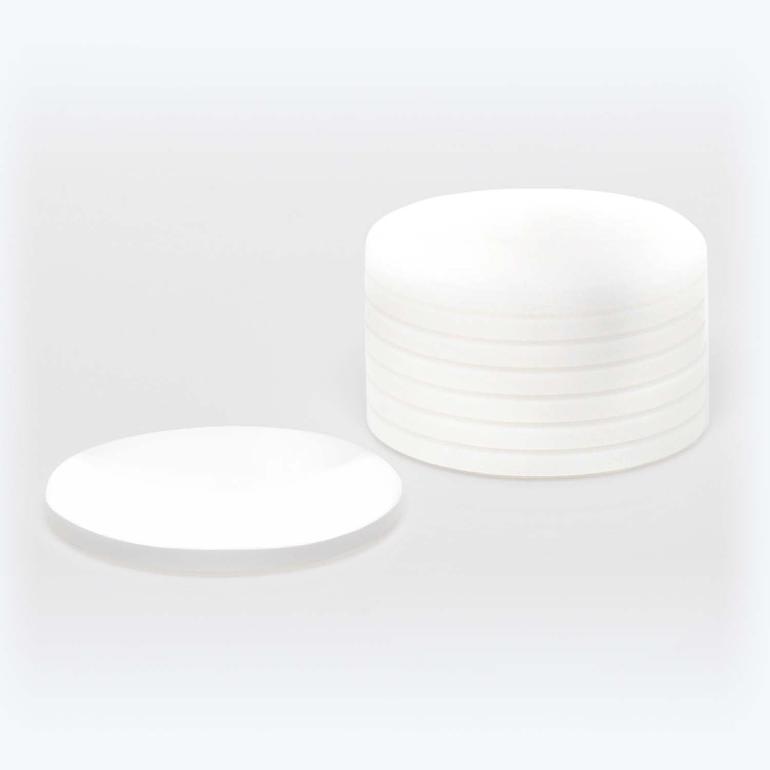Minimalistic and modern design of identical ceramic plates in soft lighting.
