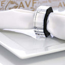 Sleek, silver wristwatch on stand showcases modern, streamlined design.