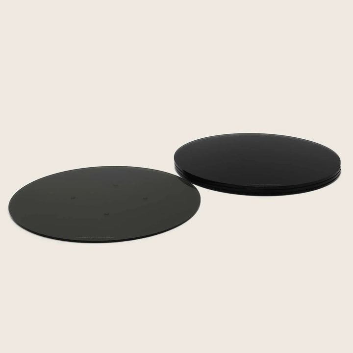 Two black, round objects with visible dots and stacked counterparts.