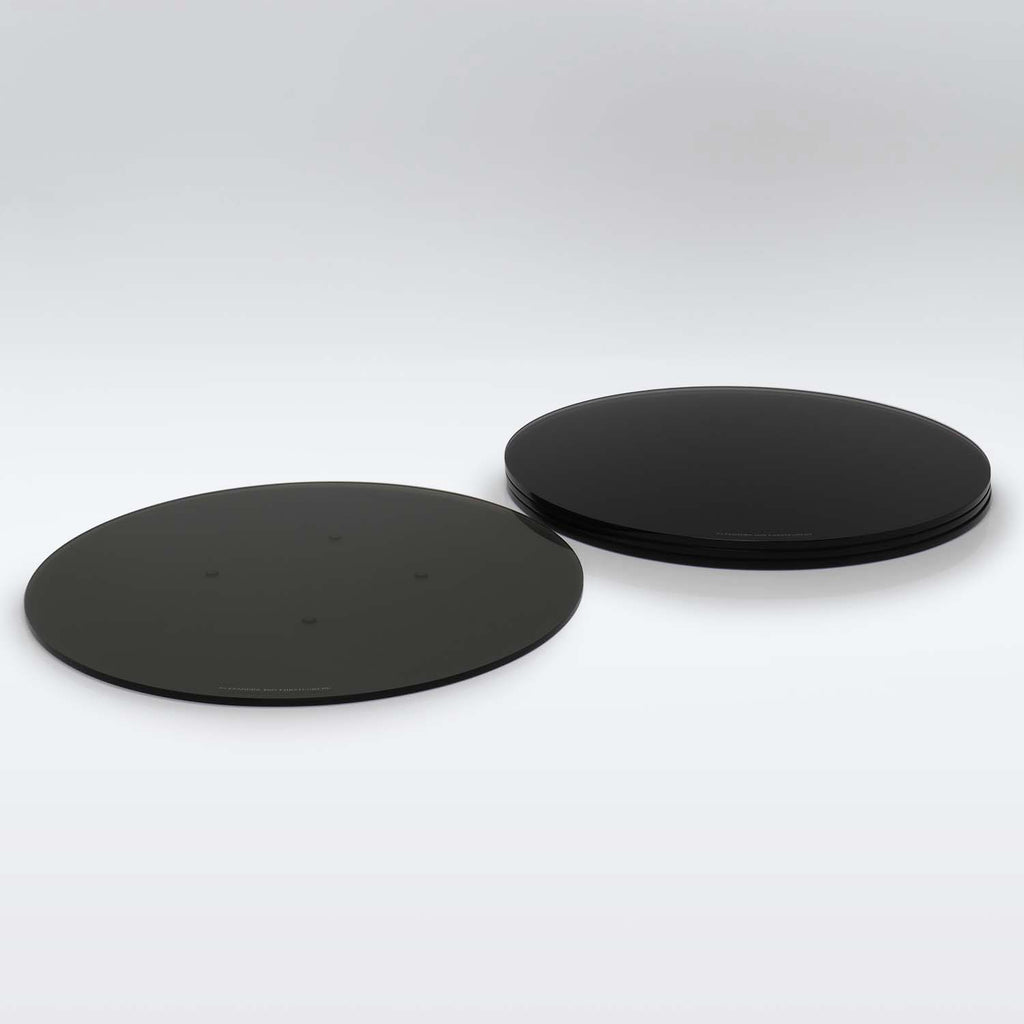 Two black, round objects with visible dots and stacked counterparts.