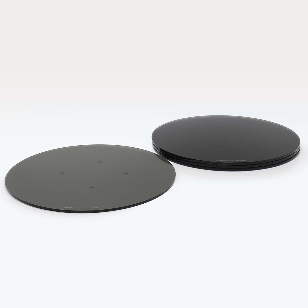 Two circular objects, one flat and matte, one glossy and stacked.