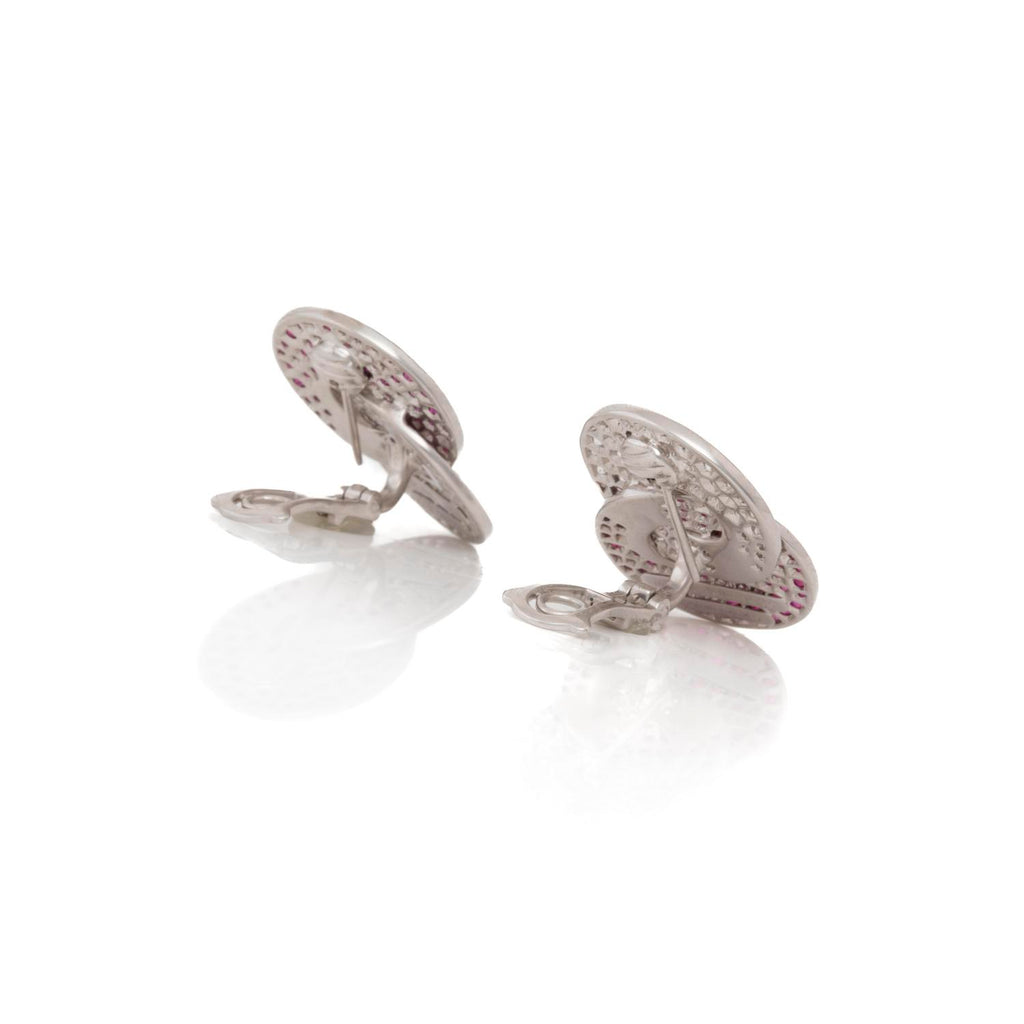 Reflective surface captures intricate, possibly rose gold cufflinks in clear reflection.