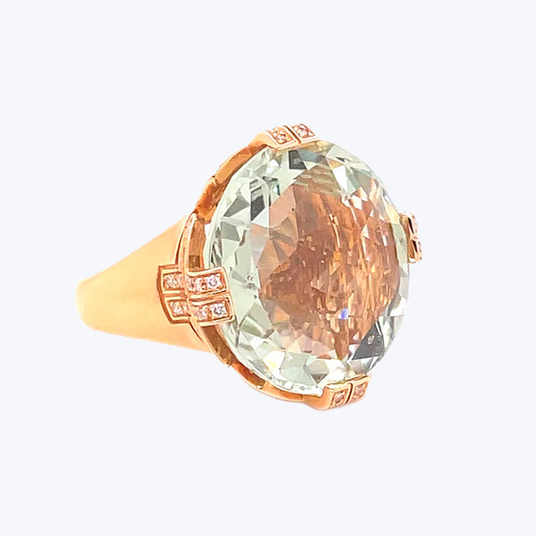 Exquisite amber gemstone ring with intricate golden band and diamonds.