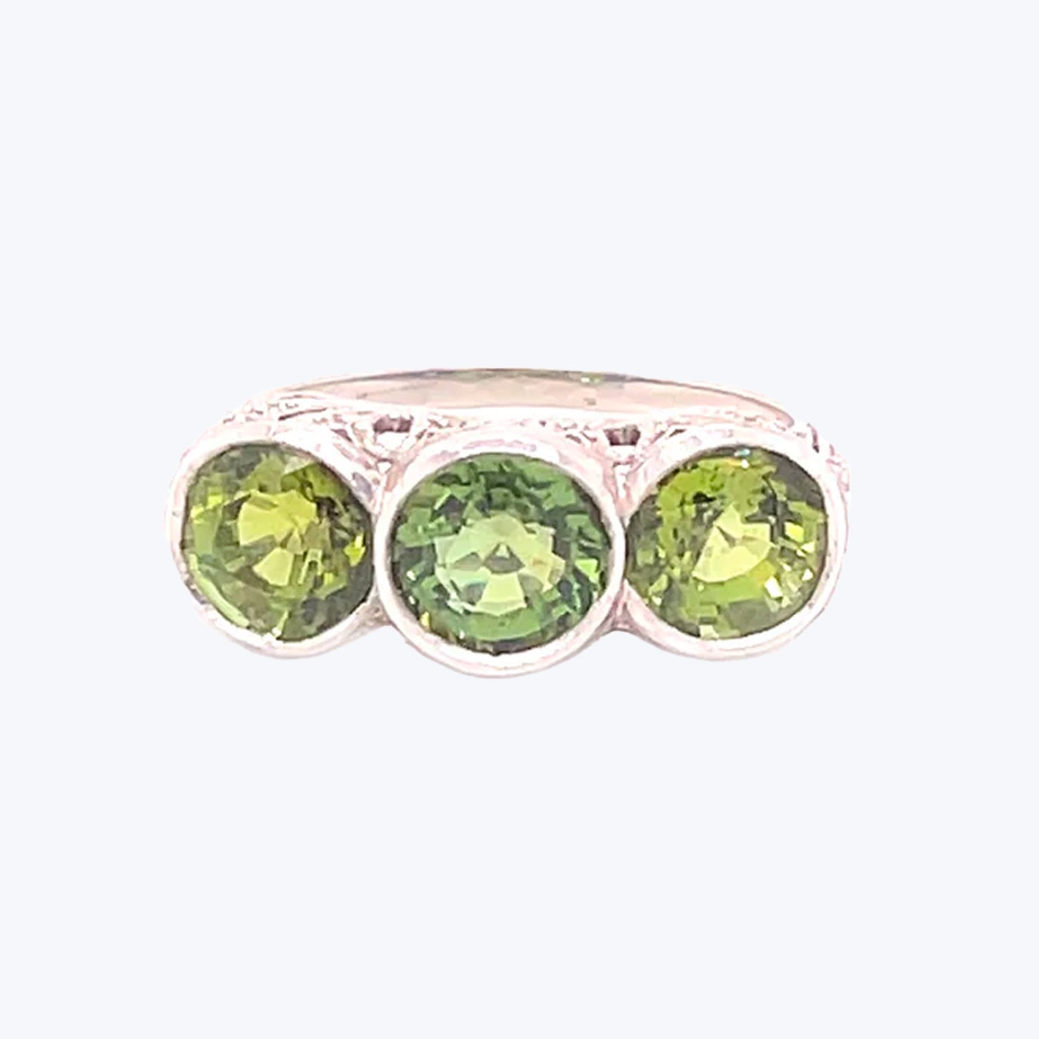 Elegant silver ring with three round-cut green gemstones.