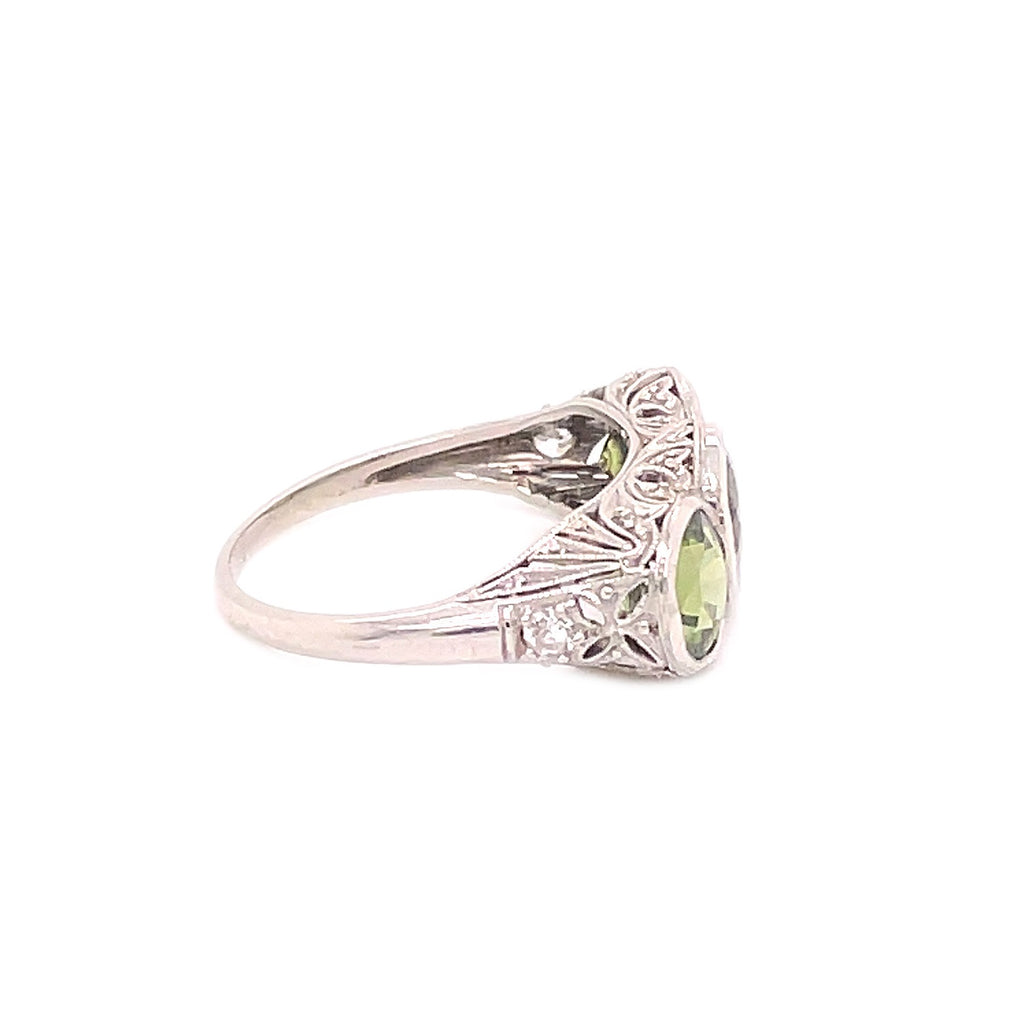 Exquisite vintage-style silver ring with a pale green gemstone centerpiece.