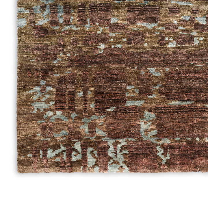 Close-up view of a patterned rug with textured, weathered appearance.