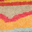 Close-up of multicolored striped rug with fluffy texture and weave pattern.