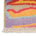 Colorful hand-made rug with wavy pattern, fringed with tassels.