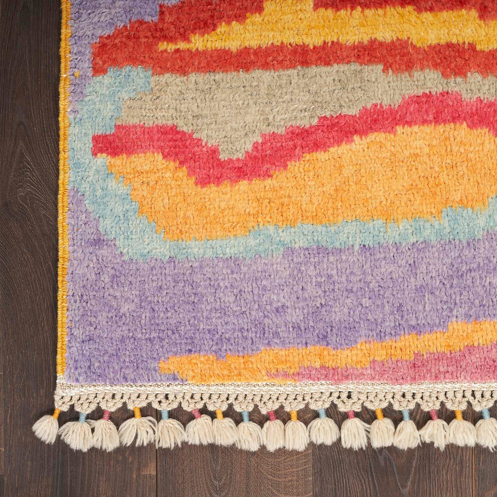Vibrant and well-maintained multicolored rug with tassel fringe on wooden floor.