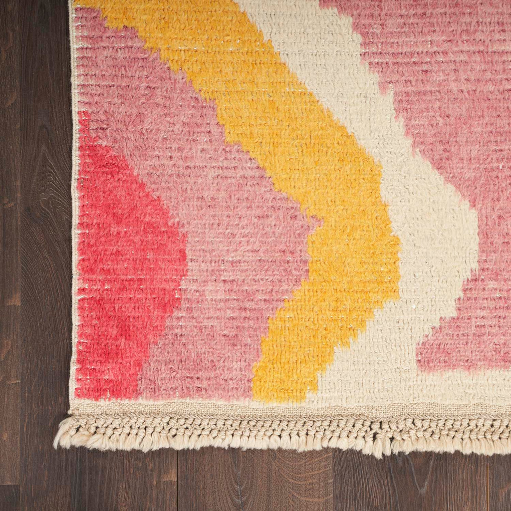 Colorful rug with abstract pattern adds vibrancy to wooden floor.