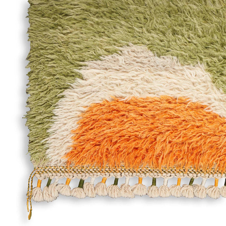 Handcrafted bohemian rug featuring a vibrant color gradient and textured fringe