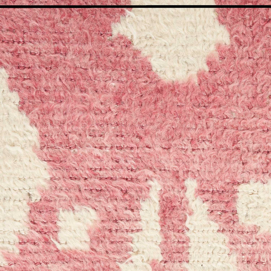 Muted pink textured fabric with fluffy appearance and irregular white patches.