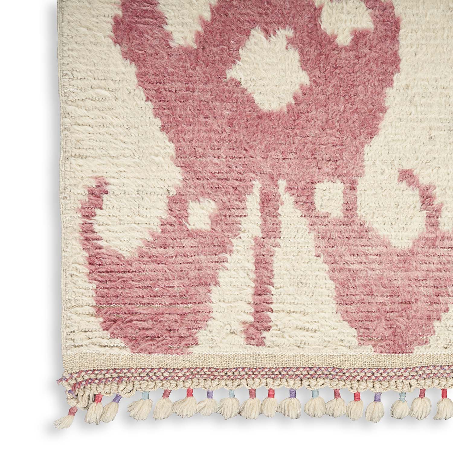 Close-up of a tufted textile rug with pink abstract design