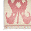 Close-up of a tufted textile rug with pink abstract design
