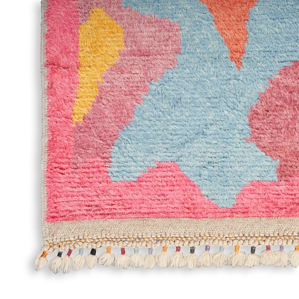 Vibrant and playful rug with abstract geometric design and tassels.