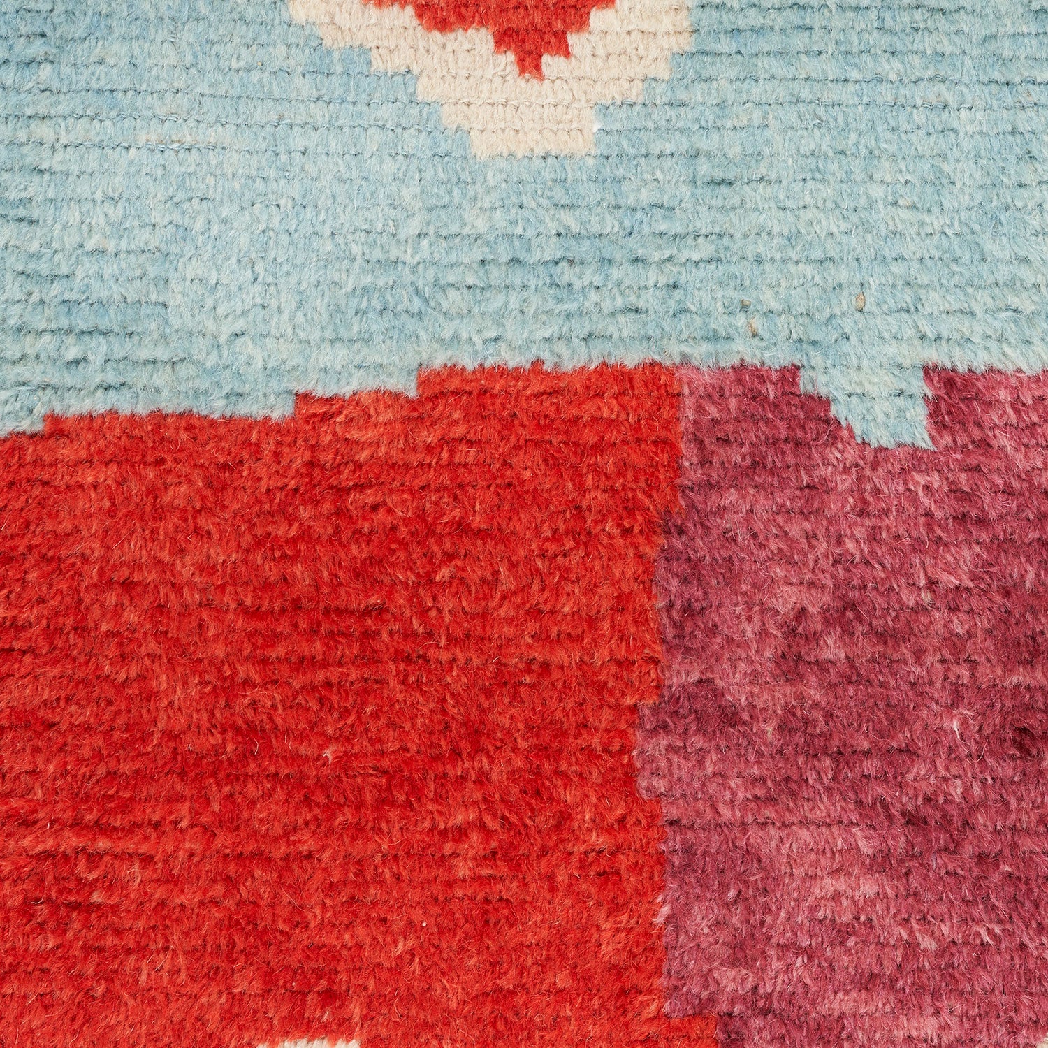 Close-up of colorful pile fabric with red, pink, and blue.