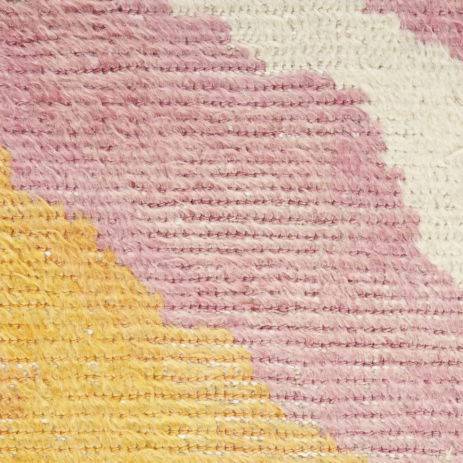 Close-up of a handmade textile with varying colors and textures.