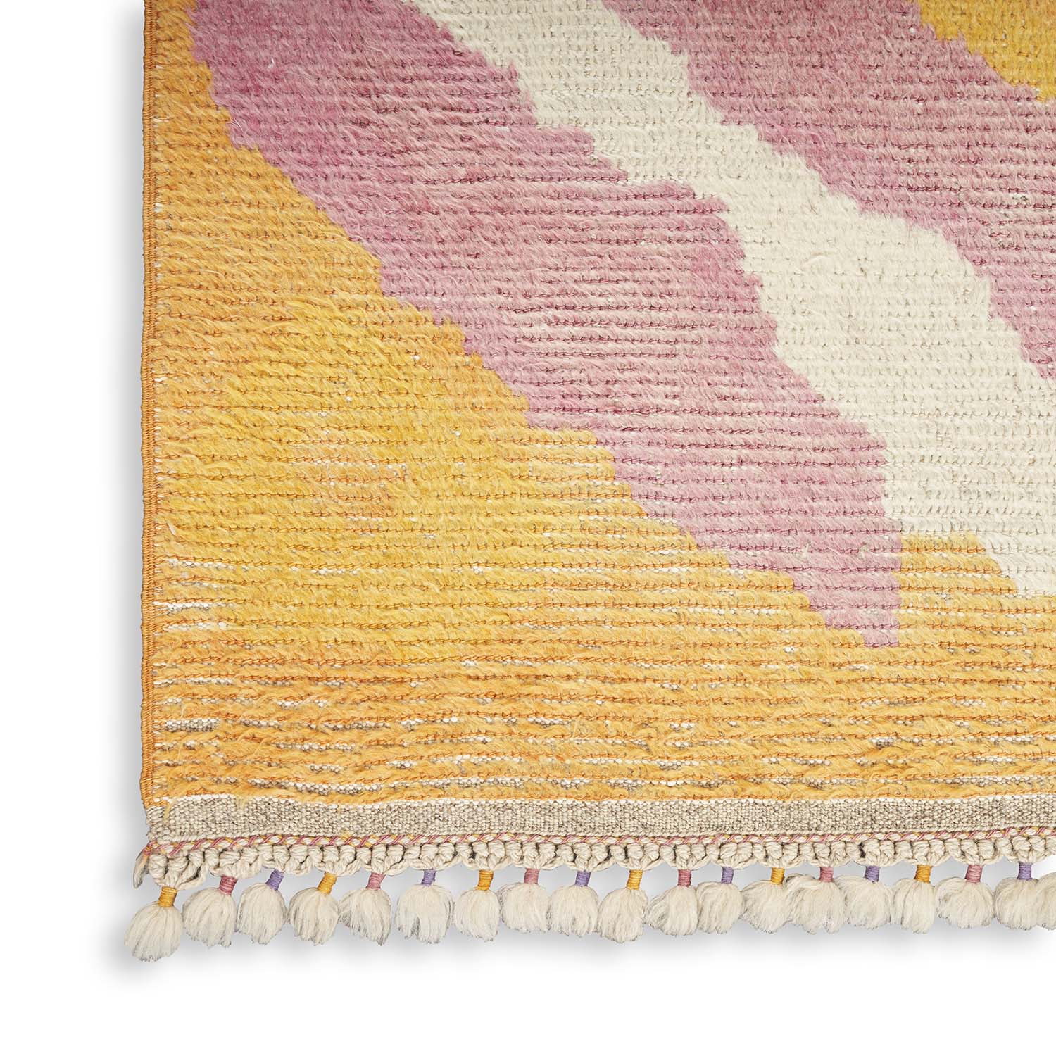 Close-up of a pastel-colored rug with tassel fringe border