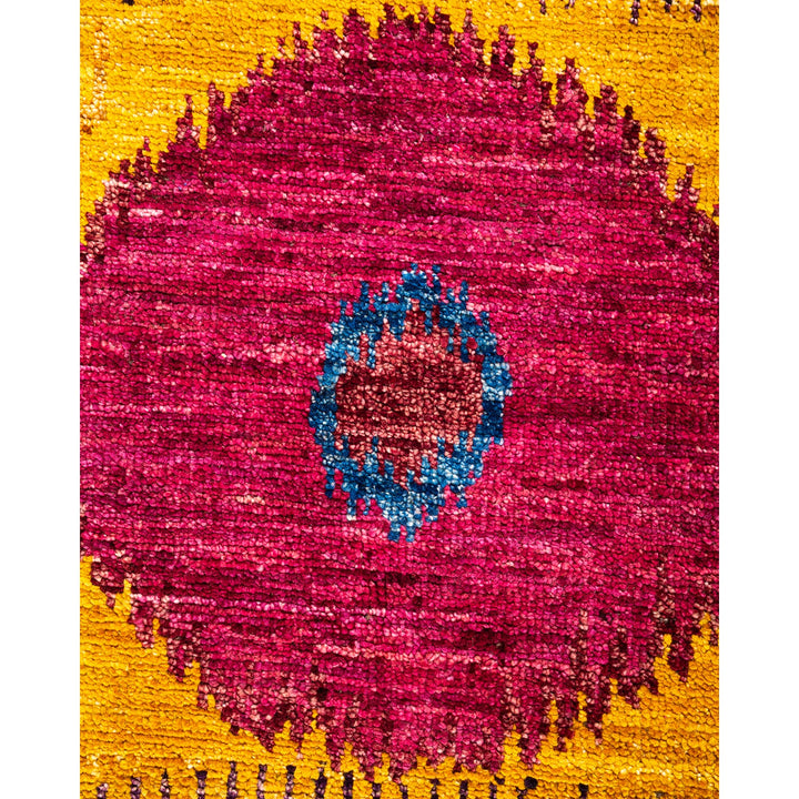 Vibrant, textured fabric pattern with central blue motif and bursts of pink and bronze.