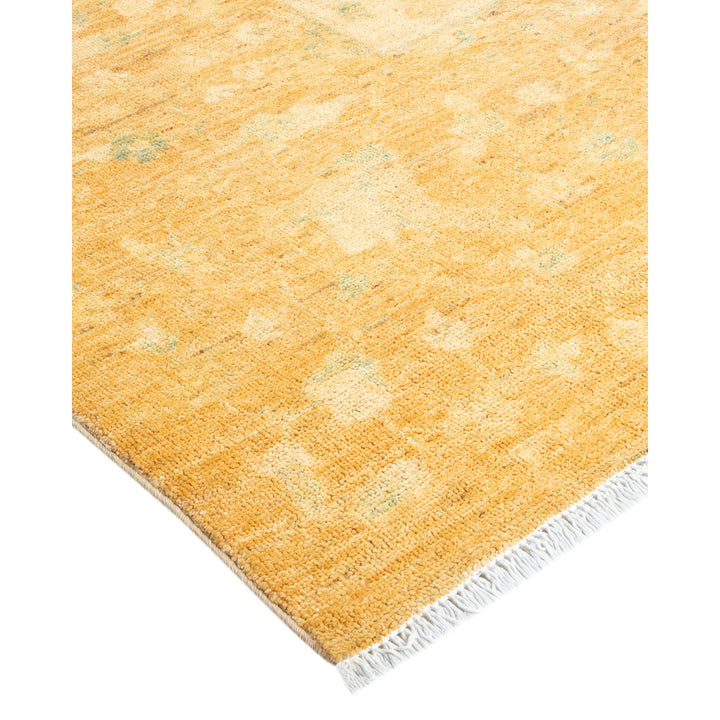 Close-up of a yellow rug with a soft texture and fringe.