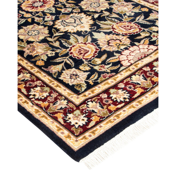 Folded traditional area rug with intricate botanical designs and plush texture
