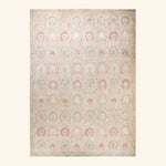 Vintage rectangular rug with ornate floral medallion pattern in pink and green.