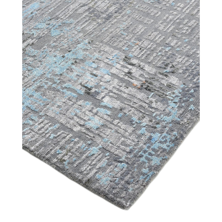Modern-style area rug with textured design and colorful splashes.