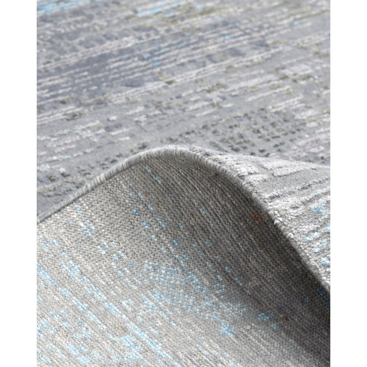 Close-up of a textured grey and blue woven carpet rug.