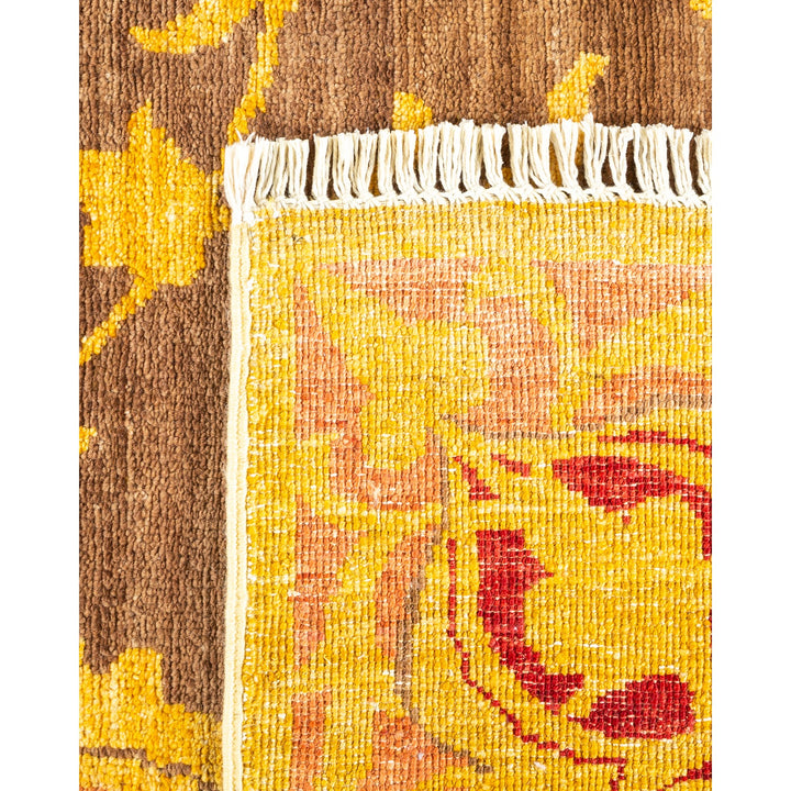 Close-up of a handwoven rug with vibrant floral patterns and tassels.
