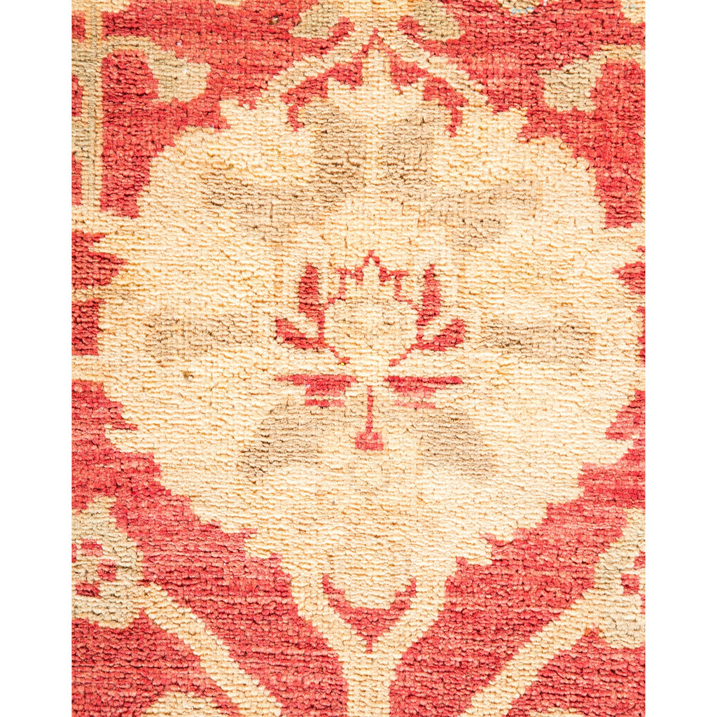 Intricate handcrafted rug showcases traditional floral motif against red background.