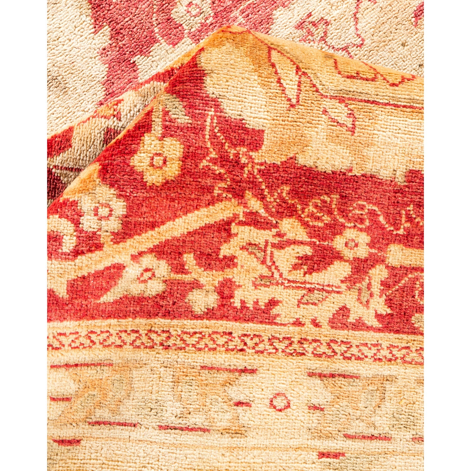 Close-up of folded corner reveals traditional patterned fabric in red and gold.