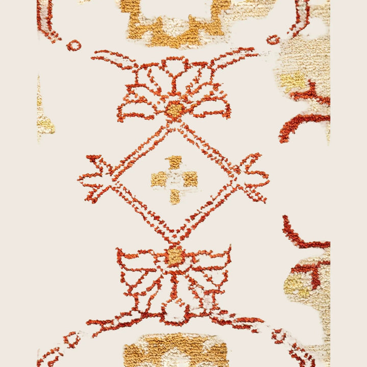 Close-up of a symmetrical, intricate patterned rug in red hues.