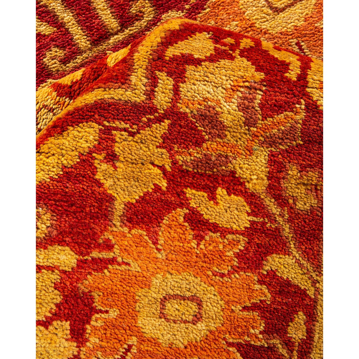 Close-up of a vibrant, ornate handwoven rug with floral motifs.