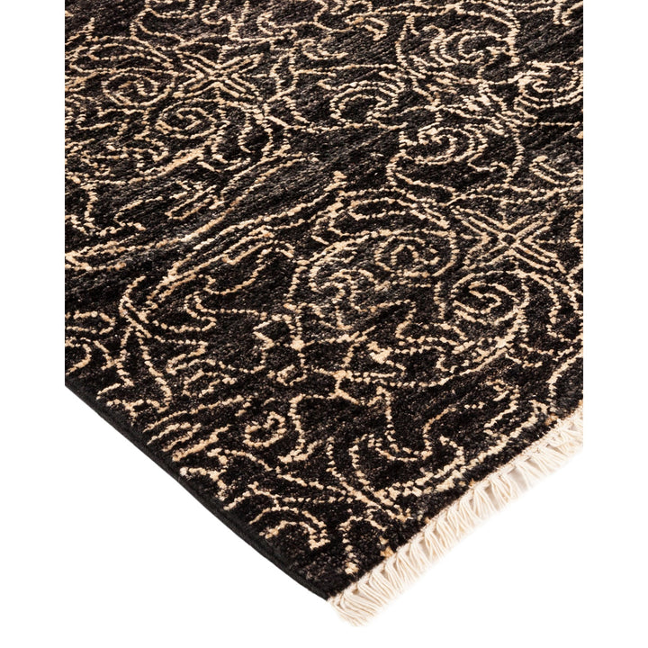 Elaborate black rug with intricate beige floral motifs and fringe