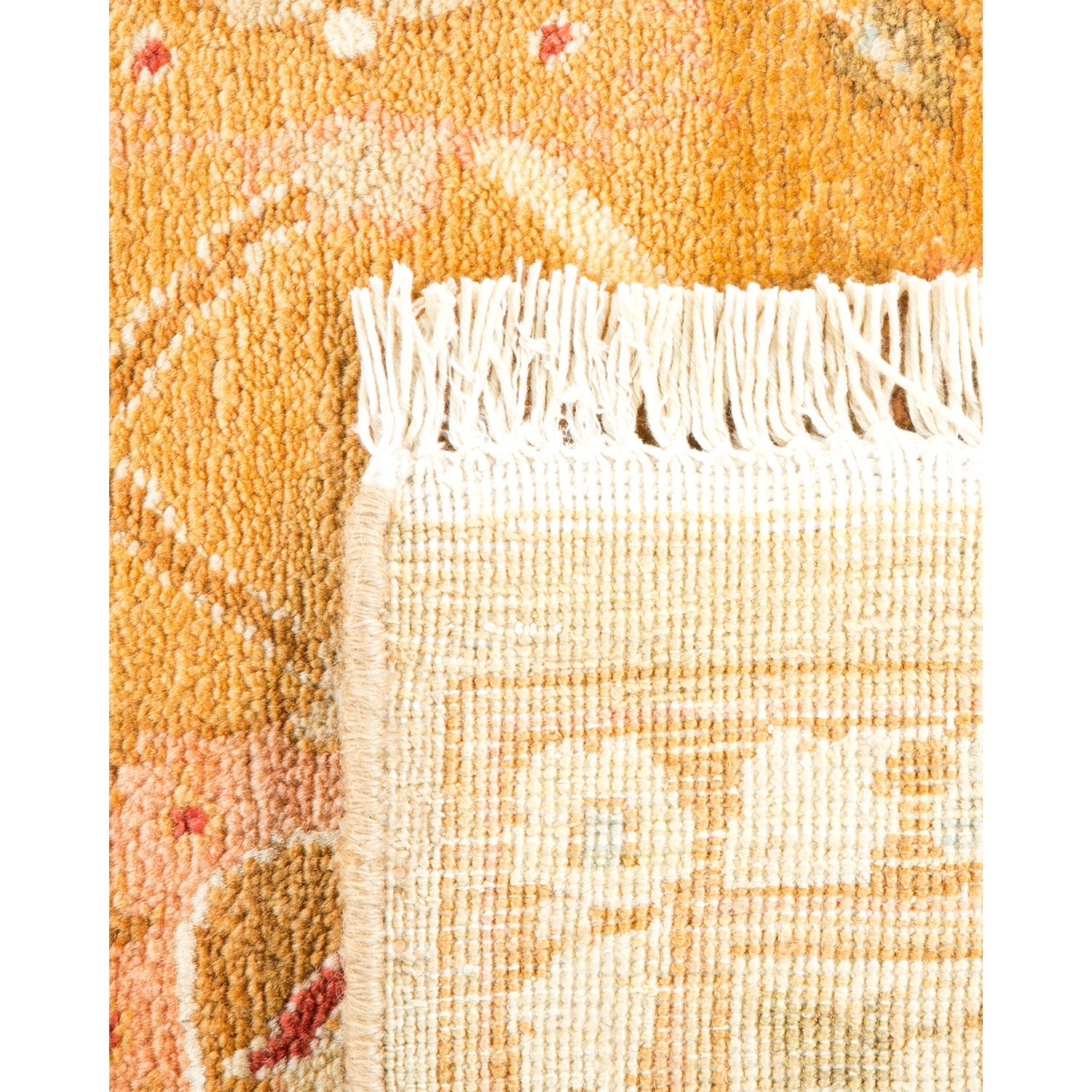 Close-up of a warm-hued rug fringe with tassels and intricate pattern.