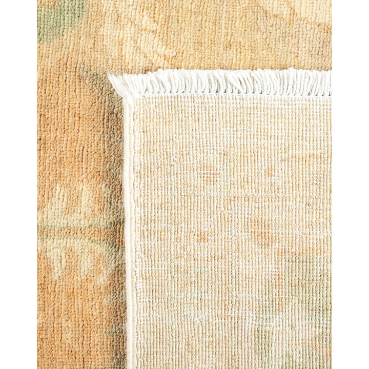 Close-up of a woven textile in muted, earthy colors with fringe.