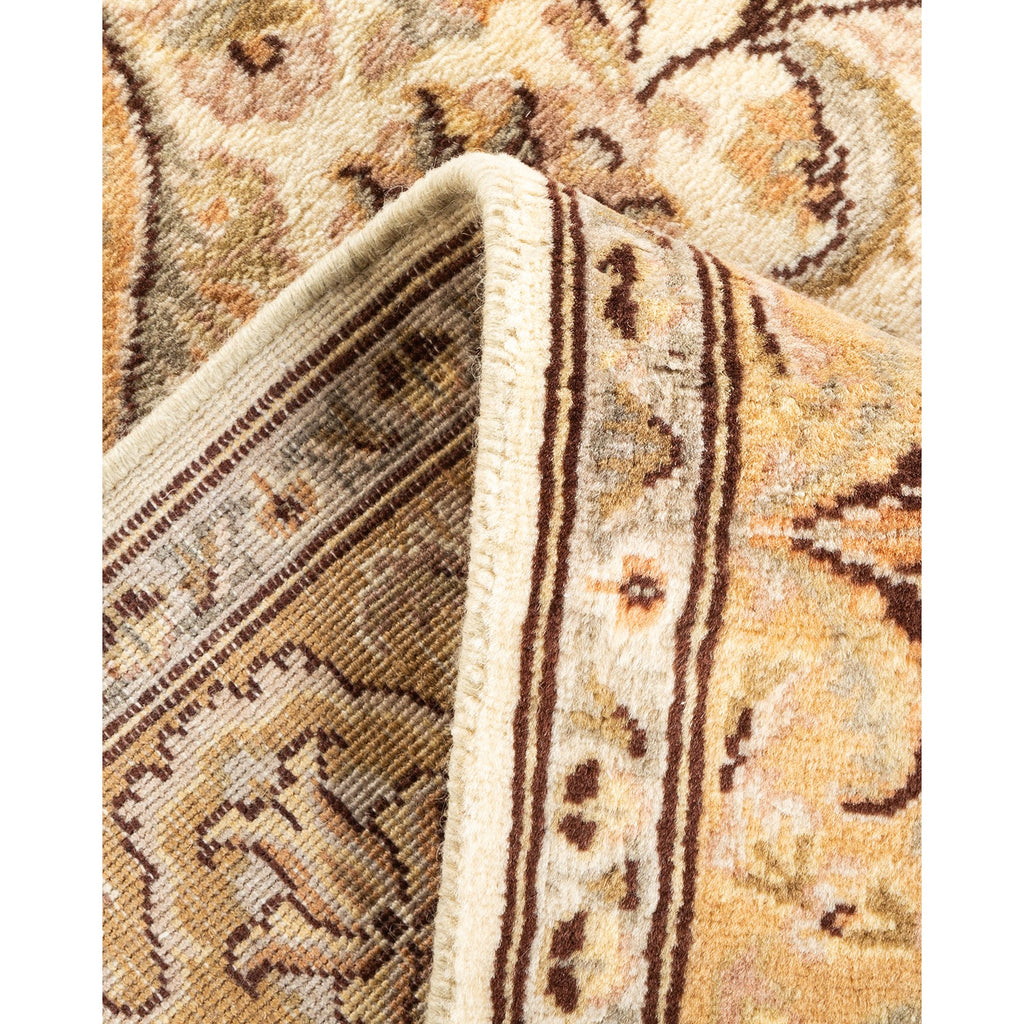 Close-up of a high-quality, intricately patterned rug in beige, brown, and cream with orange accents.