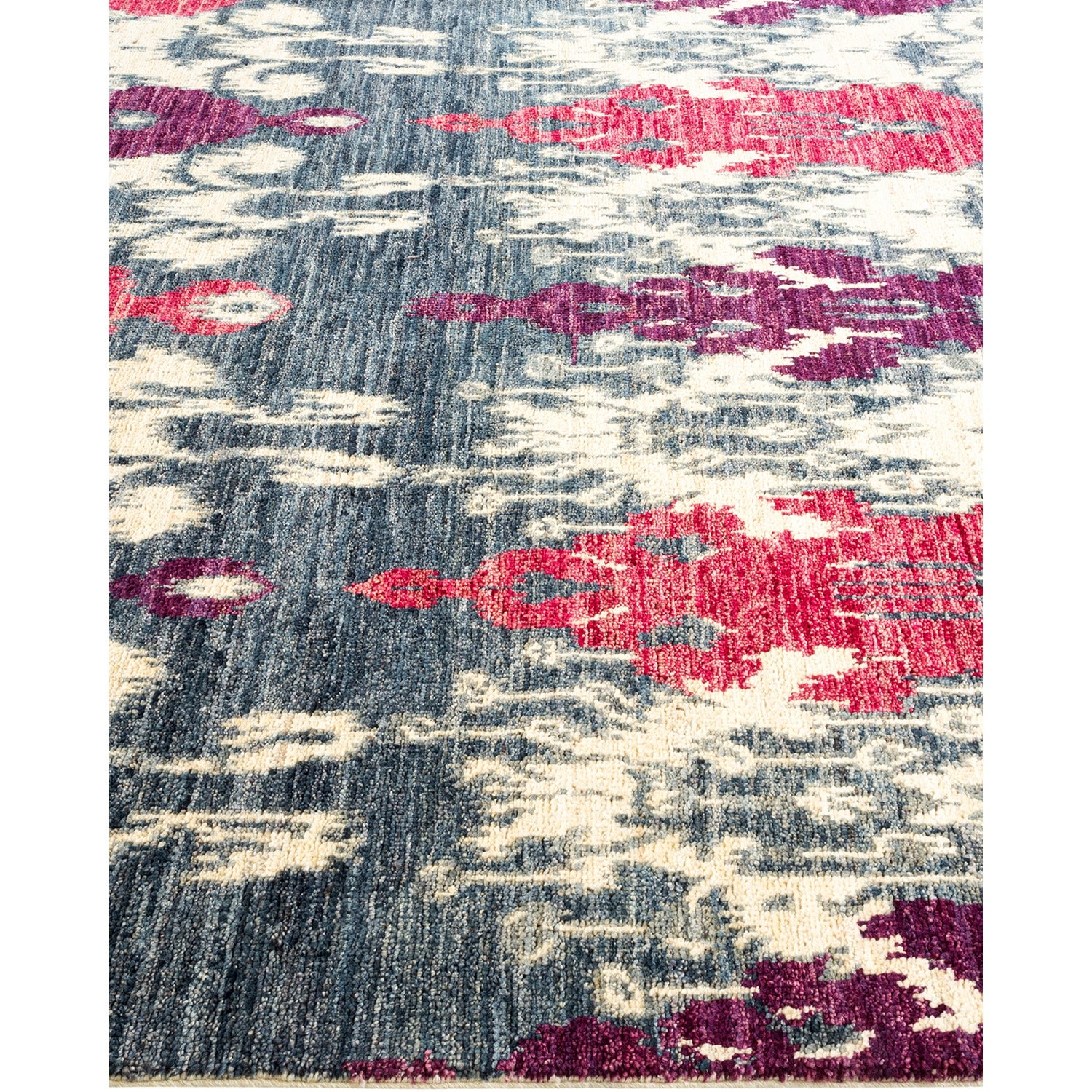 Vibrant multicolored abstract pattern on textured blue background of rug.