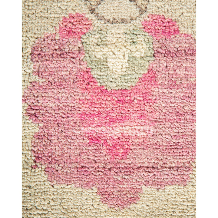 Close-up of a tufted fabric with a floral-like pink pattern.