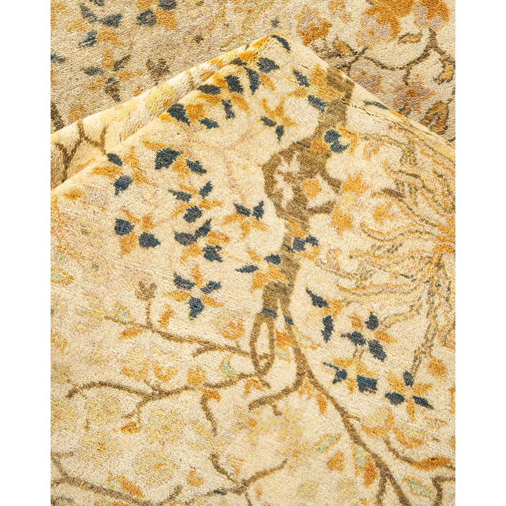 Close-up of a folded carpet with intricate floral pattern.