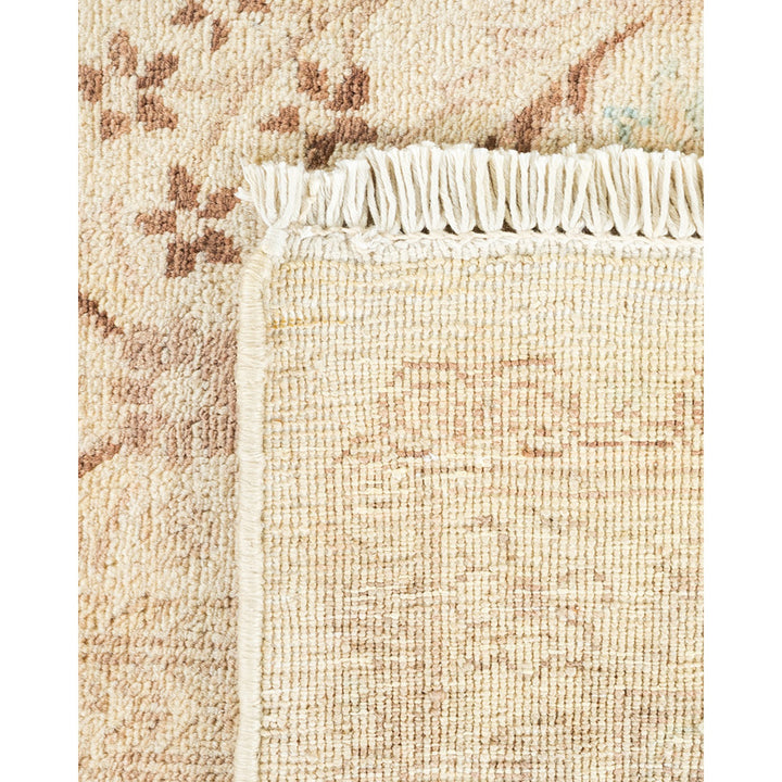 Close-up view of a rug with fringe edge and floral pattern.