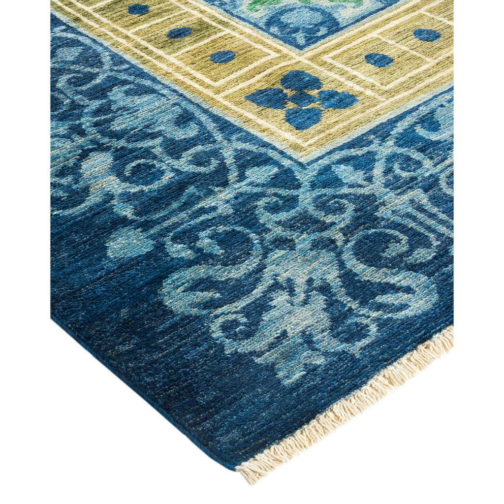 Intricate blue floral rug transitions to geometric border with fringe