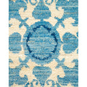 Close-up of a blue patterned rug with ornate swirling motifs.