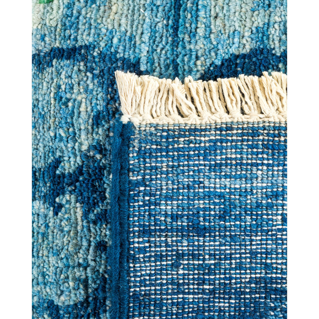 Close-up view of a textured blue rug with fringed edges.