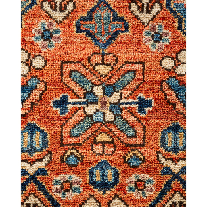 Intricate symmetrical design in blue and cream on woven rug.