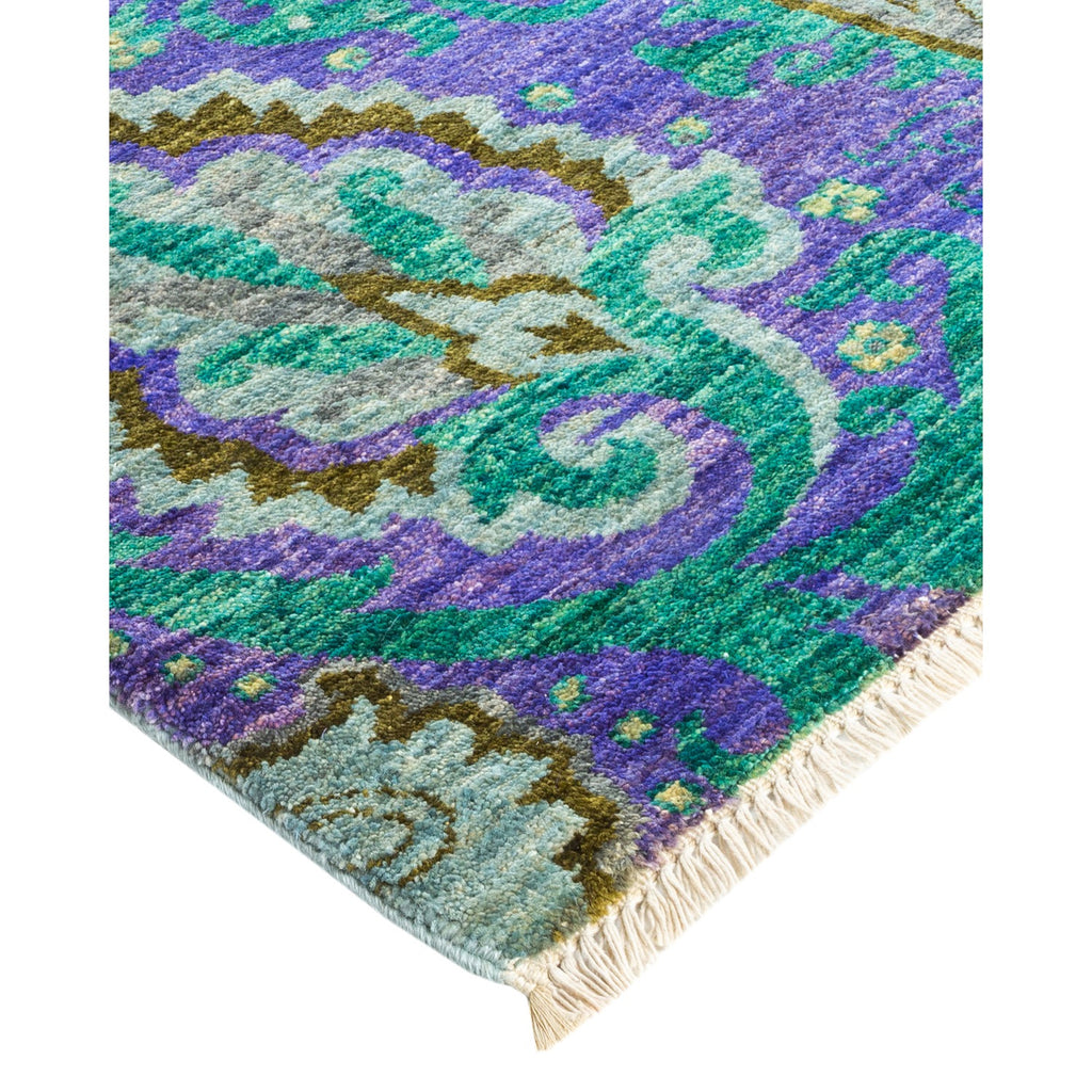 Vibrant and elaborate rug with floral-inspired pattern and fringe detail.