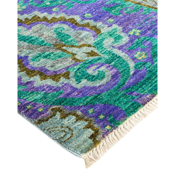 Vibrant and elaborate rug with floral-inspired pattern and fringe detail.