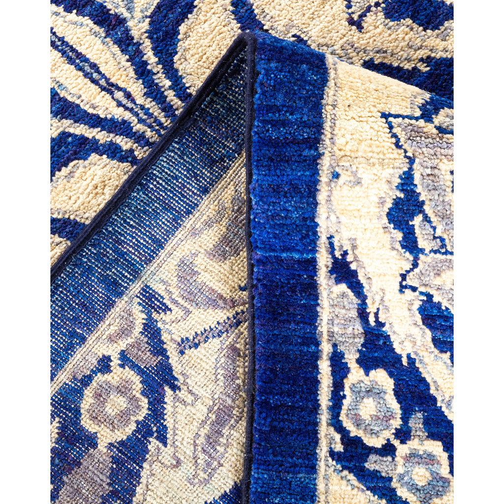 Close-up of an ornate blue and beige folded carpet.